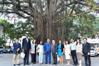 Tổng Biên tập Báo Nhân Dân Lê Quốc Minh và Phó Tổng Biên tập Báo Granma Arlin Alberty Loforte cùng cán bộ của hai cơ quan báo chí chụp ảnh lưu niệm bên gốc cây đa trong khuôn viên Báo Nhân Dân. (Ảnh: THỦY NGUYÊN)