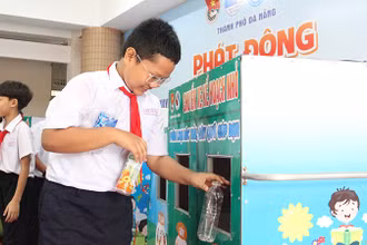 Học sinh hào hứng bỏ rác vào ngăn của chiếc xe phân loại.