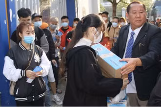 Các sinh viên, người lao động nhận quà Tết trước khi lên xe về quê vào ngày 25 tháng Chạp.