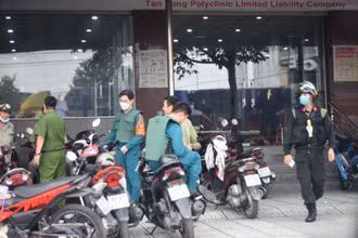 Lực lượng chức năng bao vây bên ngoài một phòng khám, chữa bệnh để phục vụ việc khám xét.