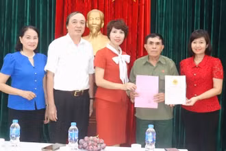 Lãnh đạo Văn phòng Hội đồng nhân dân và Ủy ban nhân dân quận Hai Bà Trưng, phường Vĩnh Tuy trao Giấy chứng nhận quyền sử dụng đất-quyền sở hữu nhà và giấy phép xây dựng cho gia đình ông Đặng Ngọc Tuy.