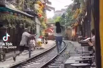 Hình ảnh một cô gái lao ra giữa đường tàu tạo dáng khi đoàn tàu hỏa đang đến gần. (Ảnh cắt từ video clip)