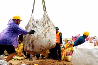 Cán bộ, nhân dân và các lực lượng vũ trang đang hỗ trợ chính quyền đắp đê gia cường bảo vệ bờ biển xã Phú Thuận sáng 11/10/2022.