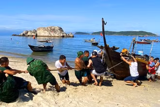 Lực lượng cứu hộ kéo tàu cá QNa-02211 lên bờ.