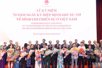 Trưởng Ban Đối ngoại Trung ương Lê Hoài Trung và Phó Thủ tướng Trần Lưu Quang tặng hoa, chúc mừng đại diện gia đình cán bộ tham gia phục vụ Hội nghị Geneve tại Lễ kỷ niệm.