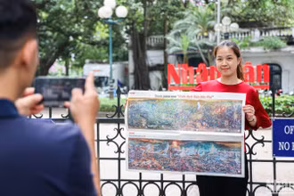 Bạn đọc hào hứng check-in cùng bức tranh panorama "Chiến dịch Điện Biên Phủ" trước trụ sở Báo Nhân Dân.