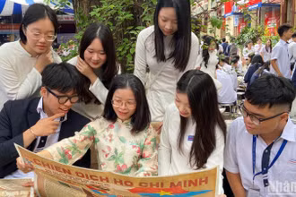 Cô và trò Trường trung học phổ thông Trần Phú xem phụ san đặc biệt về Chiến dịch Hồ Chí Minh của Báo Nhân Dân. 