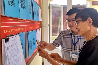Hướng dẫn nhân dân quét mã QR để tra cứu thủ tục hành chính tại phường Sông Cầu, thành phố Bắc Kạn. (Ảnh: ĐĂNG BÁCH)