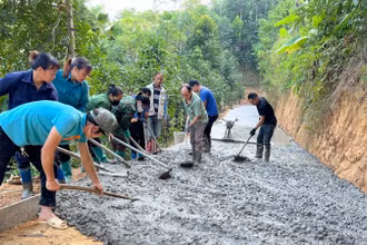 Được hỗ trợ nguyên vật liệu, người dân xã Nông Thượng, thành phố Bắc Kạn góp sức đổ bê-tông đường thôn. (Ảnh: TUẤN SƠN)