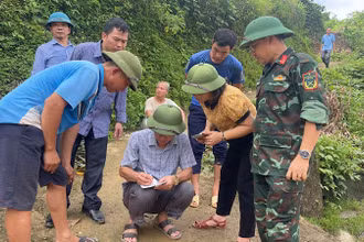 Lực lượng chức năng kiểm tra, xác định mức độ nguy cơ sạt lở tại thôn Nà Pha. (Ảnh: NGỌC HÂN).
