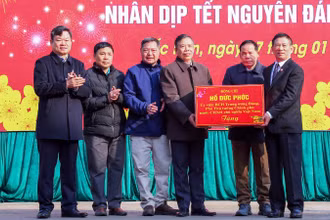 Phó Thủ tướng Chính phủ Hồ Đức Phớc tặng quà cho thị trấn Nà Phặc, huyện Ngân Sơn. (Ảnh: TUẤN SƠN)