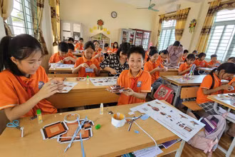 Học sinh Trường tiểu học Đại Đồng, huyện Vĩnh Tường phấn khích với mô hình Cột cờ Hà Nội của Báo Nhân Dân tặng. 