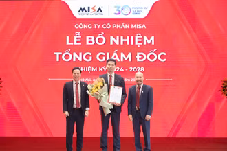 Chủ tịch HĐQT MISA Lữ Thành Long (bên phải) và Phó Chủ tịch HĐQT MISA Nguyễn Xuân Hoàng (bên trái) trao hoa và quyết định bổ nhiệm Tổng Giám đốc cho ông Lê Hồng Quang.