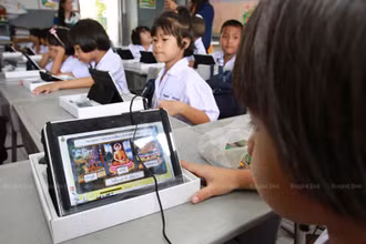 Một học sinh ở tỉnh Chachoengsao đang học cách sử dụng máy tính bảng được cấp trong chương trình của Chính phủ năm 2012. (Ảnh: Bưu điện Bangkok)