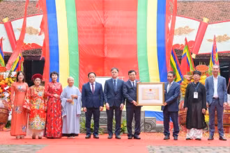 Thứ trưởng Văn hóa, Thể thao và Du lịch Hoàng Đạo Cương trao quyết định ghi danh “Lễ hội đền Hai Bà Trưng” vào danh mục Di sản Văn hóa phi vật thể Quốc gia cho đại diện lãnh đạo quận Hai Bà Trưng. (Ảnh: THẾ ĐẠI) 