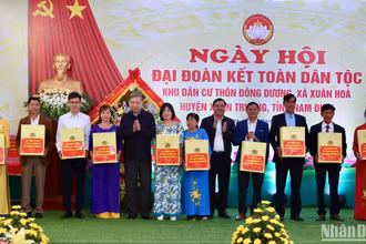 Đại tướng Tô Lâm và Bí thư Tỉnh ủy Nam Định Phạm Gia Túc tặng quà cho bà con thôn Đông Dương, xã Xuân Hòa, huyện Xuân Trường trong Ngày hội Đại đoàn kết toàn dân tộc tại địa phương.