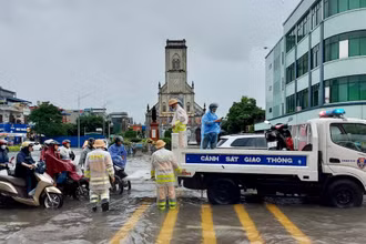 Đội Cảnh sát Giao thông-Trật tự Công an thành phố Nam Định huy động phương tiện hỗ trợ người dân qua điểm ngập.