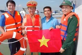 Các đơn vị phối hợp cùng phát tờ rơi, tặng áo phao cá nhân và phao cứu sinh cho chủ phương tiện vận tải trên sông Soài Rạp. (Ảnh: Mai Lan)