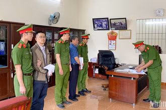 Cơ quan chức năng tống đạt quyết định khởi tố, bắt tạm giam bị can Lê Đình Thuần và Nguyễn Hữu Giảng. (Ảnh: H.Đ)