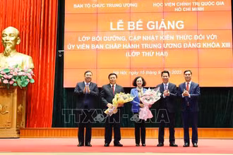 Ban tổ chức lớp tặng hoa cho đồng chí Trương Thị Mai và đồng chí Nguyễn Xuân Thắng. (Ảnh: TTXVN)