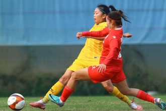 Huỳnh Như (áo vàng) tranh bóng cùng cầu thủ Than Khoáng sản Việt Nam. (Ảnh: VFF)