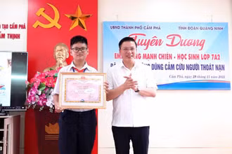 Ủy viên Ban Thường vụ Thành ủy, Phó Chủ tịch Thường trực UBND TP Cẩm Phả Đinh Ngọc Chiến trao khen thưởng cho em Hoàng Mạnh Chiến. (Nguồn: campha.gov.vn)