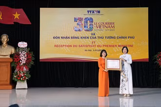 Tổng Giám đốc Vũ Việt Trang đã trao Bằng khen của Thủ tướng Chính phủ tặng Báo Le Courrier du Vietnam. (Ảnh: TTXVN)