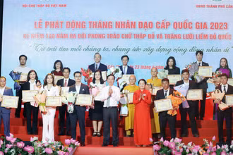 Chủ tịch nước Võ Văn Thưởng, Chủ tịch danh dự Hội Chữ thập Đỏ Việt Nam và bà Bùi Thị Hòa, Chủ tịch Hội Chữ thập Đỏ Việt Nam tặng hoa và trao bảng Ghi nhận tấm lòng vàng nhân đạo. (Ảnh: TTXVN) 