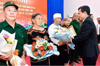 Bí thư Tỉnh ủy Hồ Văn Niên tặng hoa, bằng khen cho các đại biểu người có công và thân nhân liệt sĩ. (Ảnh: Đức Thụy)