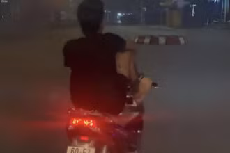 Võ Văn Tâm dùng chân điều khiển xe máy trên đường Hà Huy Giáp.