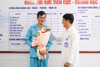 Tiến sĩ, bác sĩ Lê Đức Nhân, Giám đốc Bệnh viện Đà Nẵng tặng hoa, chúc mừng bệnh nhân, sáng 27/11. (Ảnh: ANH ĐÀO)