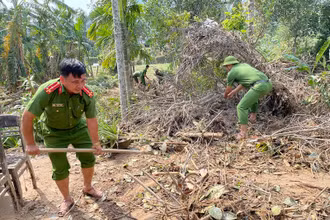 Thượng úy Bùi Văn Hoàng cùng cán bộ chiến sỹ Công an xã Hoà Bắc giúp dân dọn nhà sau bão lũ. Ảnh Công an xã Hoà Bắc