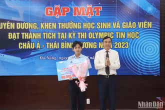 Chủ tịch UBND thành phố Lê Trung Chinh tặng Bằng khen và tiền thưởng cho học sinh Lê Ngọc Bảo Anh. (Ảnh: ANH ĐÀO)