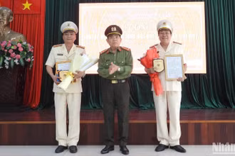 Đại tá Trần Đình Liên, Phó Bí thư Đảng ủy, Phó Giám đốc Công an thành phố Đà Nẵng trao quyết định nghỉ hưu theo chế độ cho 2 cán bộ lãnh đạo cấp phòng là Đại tá Đặng Văn Khuôn, Trưởng Công an quận Cẩm Lệ nghỉ công tác, hưởng chế độ hưu trí từ ngày 1/3 và Thượng tá Nguyễn Chính, Phó trưởng Phòng Tham mưu nghỉ công tác, hưởng chế độ hưu trí từ ngày 1/4. (Ảnh: ANH ĐÀO)