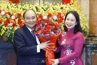 Quyền Chủ tịch nước Võ Thị Ánh Xuân tặng hoa nguyên Chủ tịch nước Nguyễn Xuân Phúc. (Ảnh: THỐNG NHẤT/TTXVN)