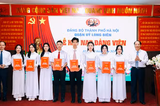 Trưởng Ban Tuyên giáo Thành ủy Hà Nội Nguyễn Doãn Toản và Bí thư Quận ủy Long Biên Đường Hoài Nam trao Quyết định kết nạp đảng viên.