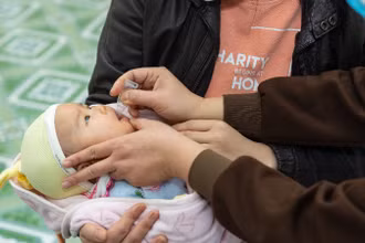Cho trẻ uống vaccine Rota tại trung tâm y tế. 
