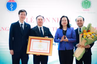 Bộ trưởng Y tế Đào Hồng Lan trao Bằng khen của Thủ tướng Chính phủ cho lãnh đạo Bệnh viện Răng Hàm Mặt Trung ương. (Ảnh: HẢI NGUYỄN)