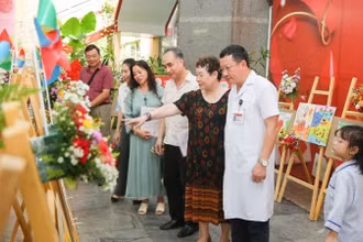 Các đại biểu tham quan triển lãm tranh vẽ của các bạn nhỏ mắc bệnh thalassemia.