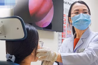 Thạc sĩ, bác sĩ chuyên khoa II Trần Thị Thúy Hằng, Trưởng khoa Tai Mũi Họng, Trung tâm Tai Mũi Họng đang nội soi mũi họng cho một người bệnh.