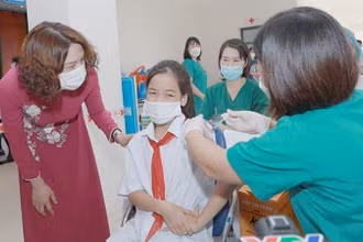 Thứ trưởng Nguyễn Thị Liên Hương động viên các em học sinh tham gia tiêm chủng.