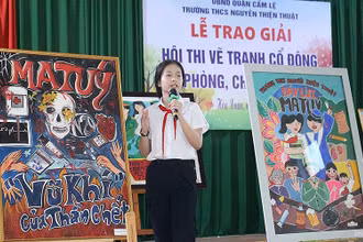 Học sinh trình bày ý nghĩa tác phẩm tại lễ trao giải Hội thi vẽ tranh cổ động về phòng, chống ma túy tại quận Cẩm Lệ (thành phố Đà Nẵng). (Ảnh ĐINH NGA) 