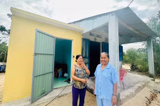 Mẹ con chị Phan Thị Mỹ Nhung ở xã Tam Thanh, thành phố Tam Kỳ bên căn phòng tránh bão.