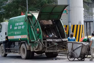 Công nhân Công ty Môi trường đô thị Hà Nội thu gom rác thải ở quận Đống Đa. (Ảnh PHẠM HÙNG)