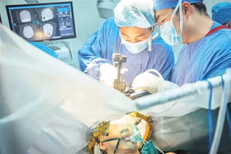 Các bác sĩ Bệnh viện Hữu nghị Việt Đức thực hiện thành công ca phẫu thuật kích thích não sâu cho bệnh nhân rối loạn trương lực cơ toàn thể. (Ảnh NGỌC ĐỨC)