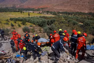 Các nhân viên cứu hộ đang tìm kiếm người mất tích. Ảnh: Reuters.