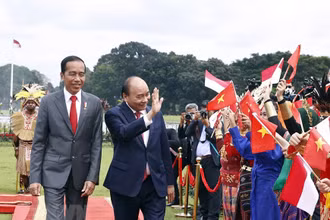 Chủ tịch nước Nguyễn Xuân Phúc và Tổng thống nước Cộng hòa Indonesia Joko Widodo tại lễ đón. (Ảnh: TTXVN)