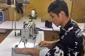 Anh Lường Văn Hiếu, một trong những tấm gương “Tỏa sáng nghị lực Việt”, cần mẫn lao động trên bàn may mỗi ngày.