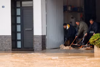 Người dân ngăn chặn nước vào nhà. Ảnh: Reuters.