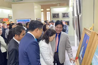 Họa sĩ Nguyễn Văn Trường (thứ 3 bên phải) giới thiệu tranh tại triển lãm.